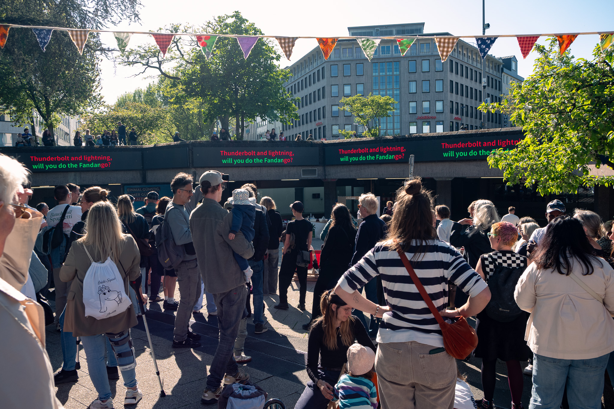 Menschen stehen vor einem großen karaoke Screen am Ebertplatz.